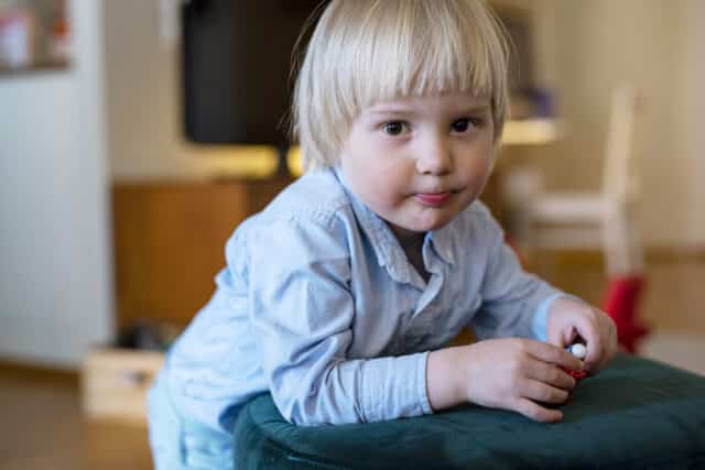 Kuvituskuva. Pieni lapsi nojaa penkkiin.
